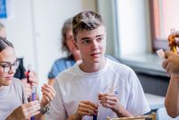 drei Personen die Reagenzgläser in der Hand halten