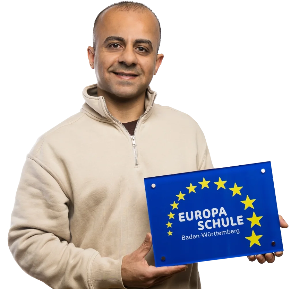 Ein Schüler der ein Schild in der Hand hält und lacht.